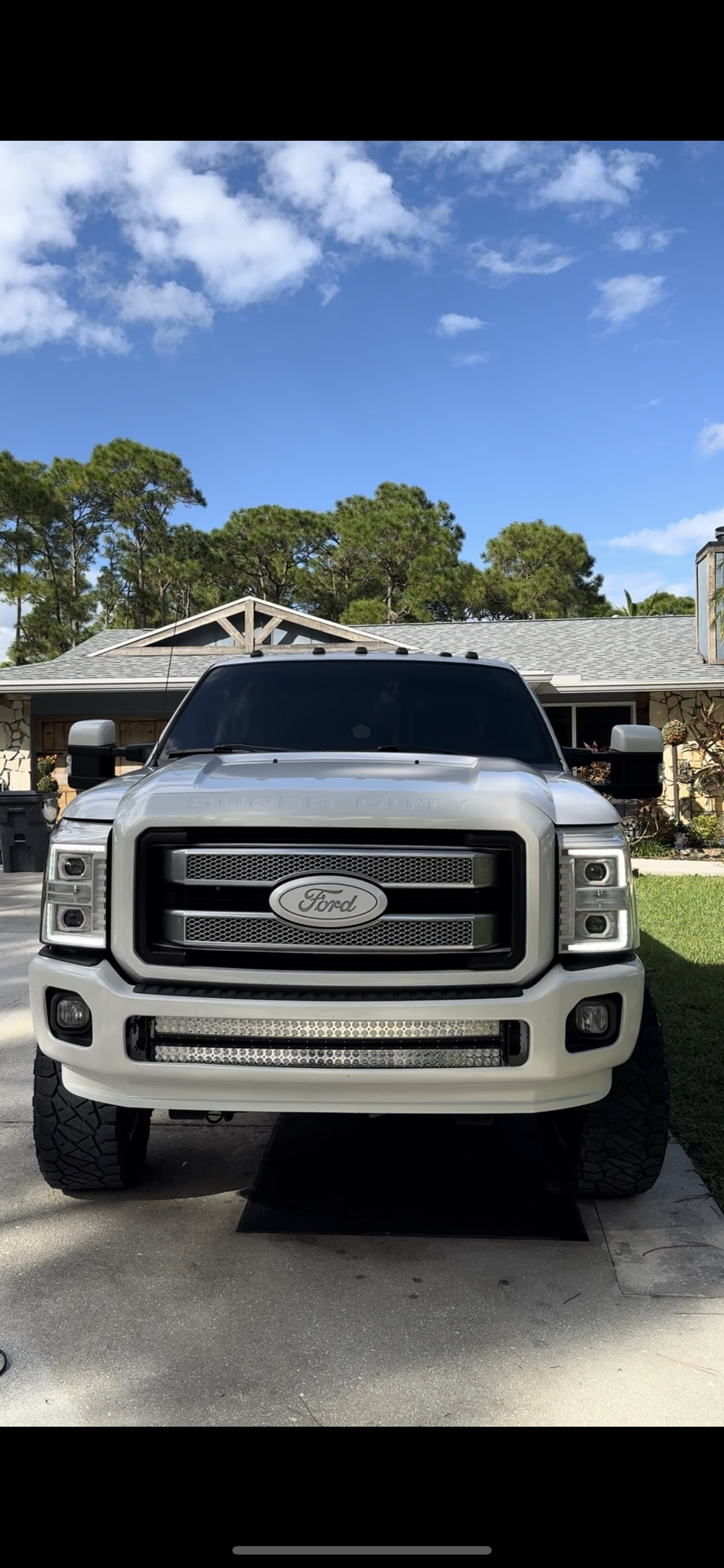 White Ford Super Duty truck parked in front of a house