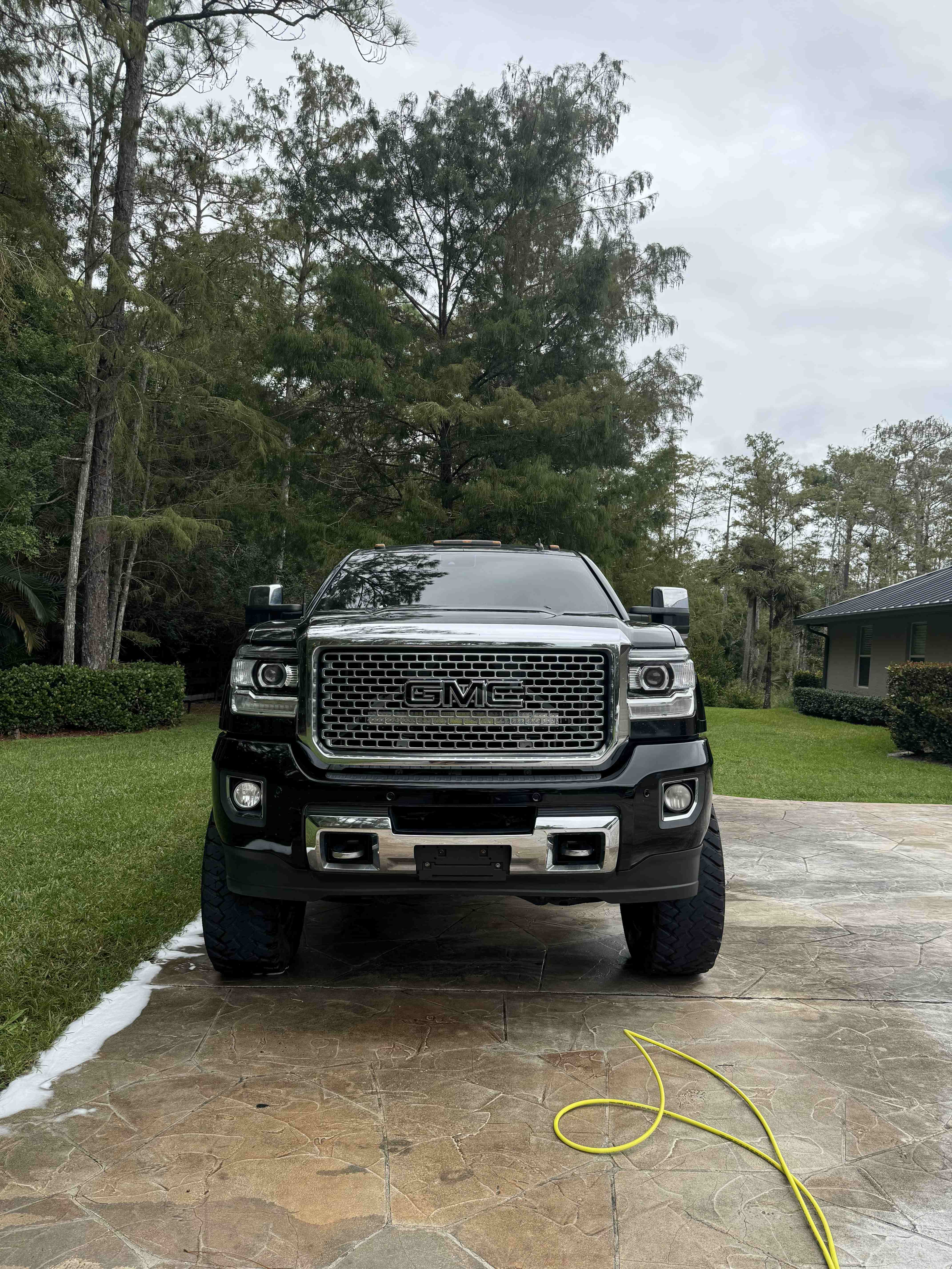 Black GMC Sierra Denali on a freshly washed driveway